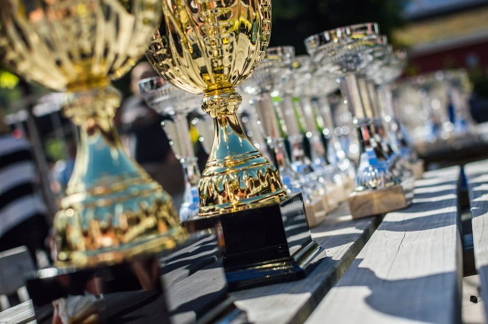 Gold and silver trophies on a wooden table
