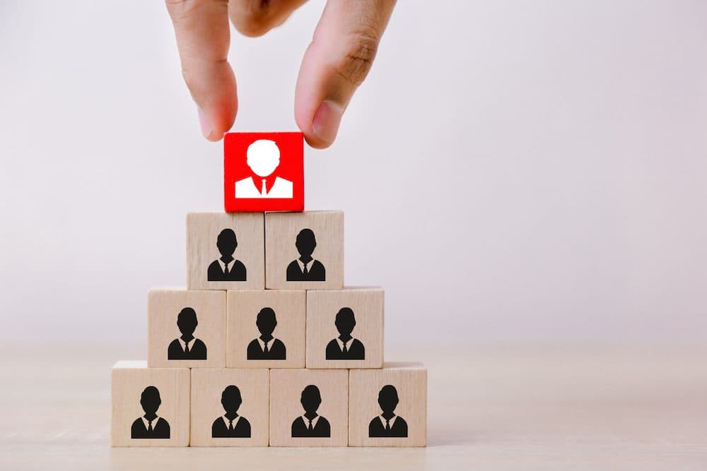 Hand business putting wood cube block on top pyramid,human resource management and recruitment business concept, Business Strategy to success. - Image (Hand business putting wood cube block on top pyramid,human resource management and recruitment busi