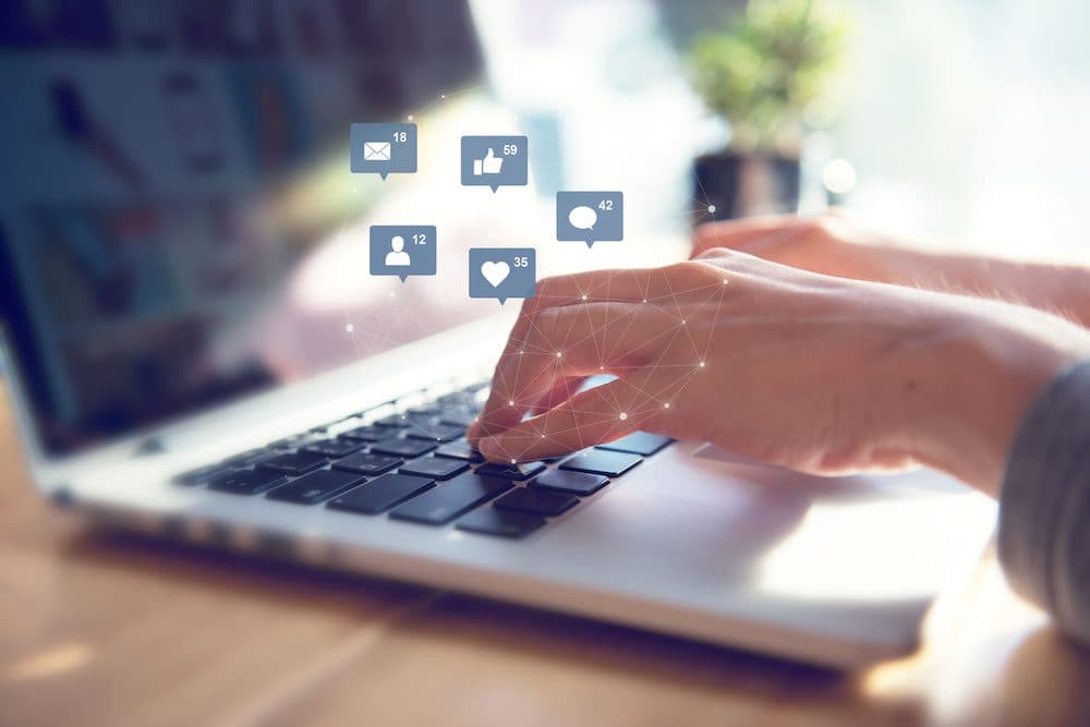 Businesswoman hands using laptop with icon social media and social network, Marketing concept.