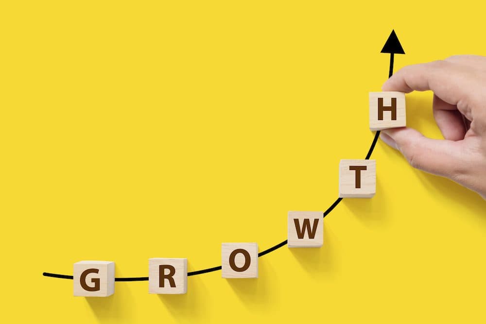 Business success growing growth increase up concept. Wooded cube block on white background with word GROWTH and copy space for your text (Business success growing growth increase up concept. Wooded cube block on white background with word GROWTH and c