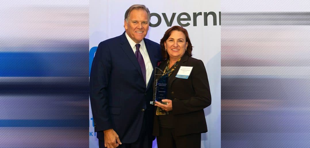 Guidehouse's Marianne Bailey with emcee Mike Rogers at the 2019 Pinnacle Awards.