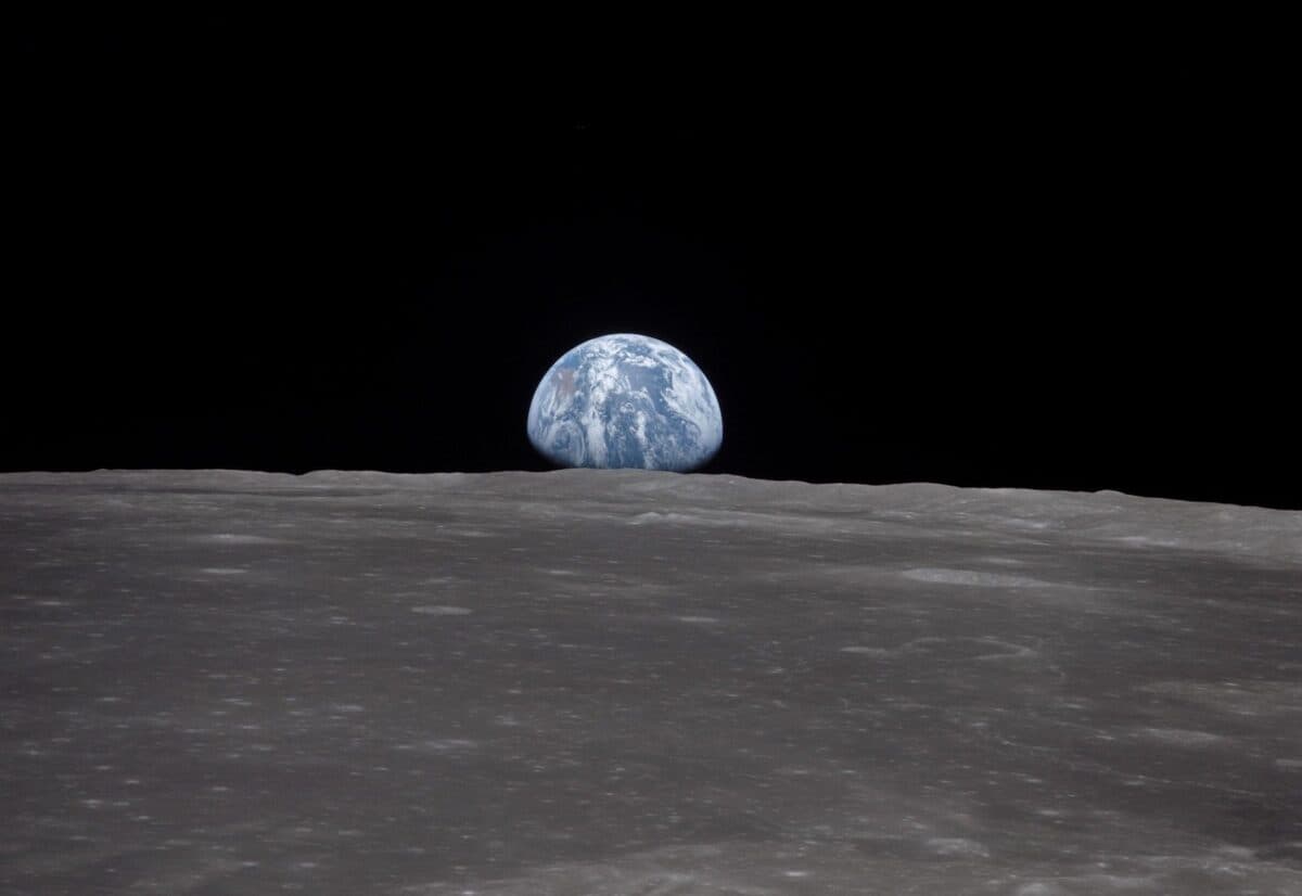 This view from the Apollo 11 spacecraft shows the Earth rising above the Moon's horizon in July 1969. The lunar terrain pictured is in the area of Smyth's Sea on the nearside.