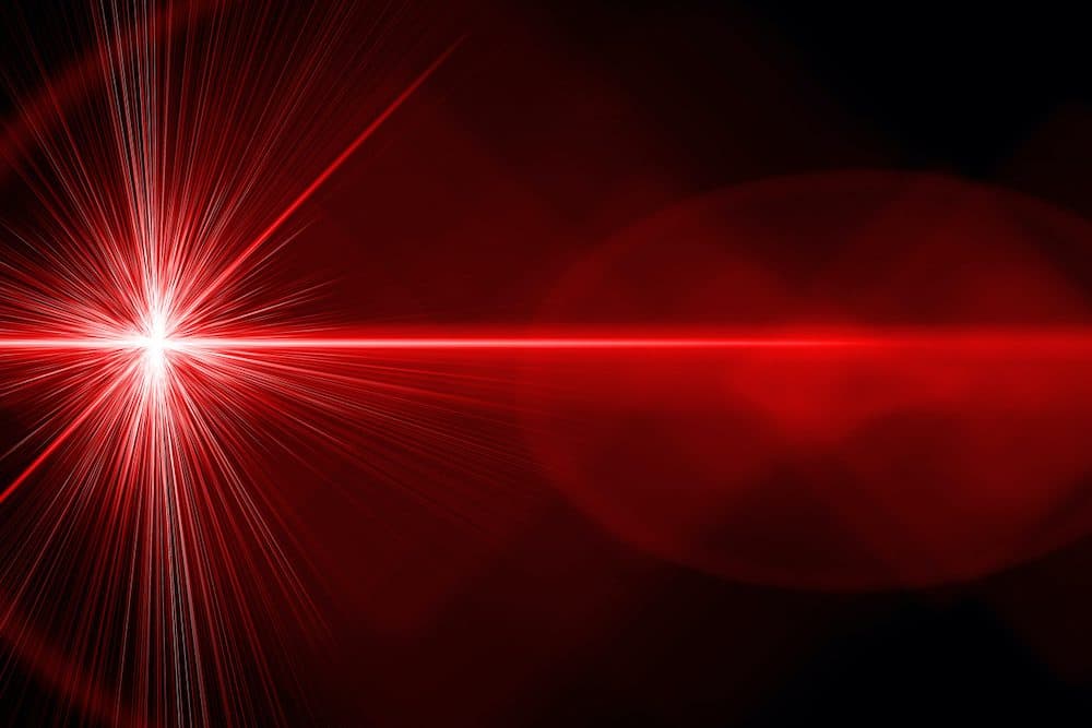 A red bright laser ray on black background