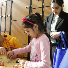 Virginia Run Elementary School student Bonnie Gill, 5, tries a science experiment with the help of Ishaan Lubana of the Children's Science Center while her mother Sheena Gill looks on, at the 2015 K-12 STEM Symposium