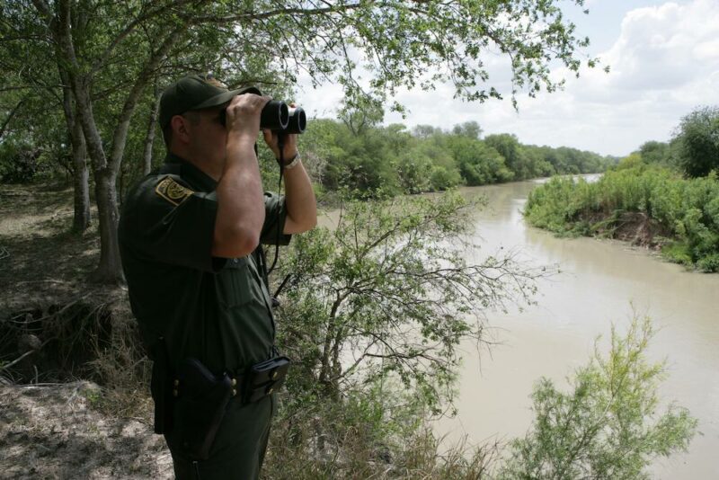 In this file photo from 2016, a Border Patrol agent scans the area into Mexico with binoculars. Photo: USBP